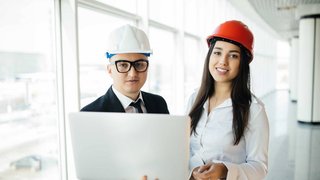 engineering-architecture-concept-engineers-working-building-site-holding-laptop-architect-man-working-with-engineer-woman-inspection-workplace-architectural-plan
